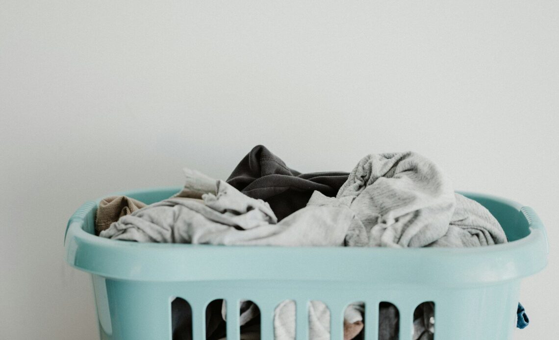 white textile on blue plastic laundry basket